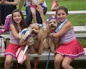 Two girls pose with three dogs all decked in red, white and blue on July 4