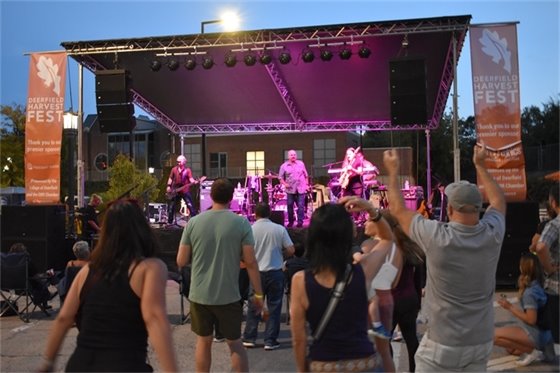 Photo of people dancing while watching the band play on the stage on Park Avenue