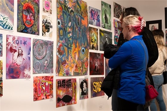 Photo of people looking at colorful student artwork