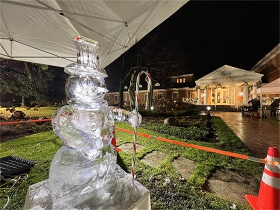 Ice sculpture of a snow man light from behind in front of Village Hall