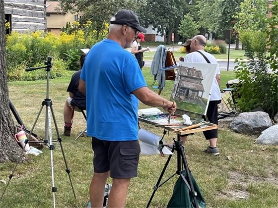 Photo of people painting the buildings at the Historic Village