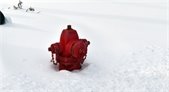 Photo of a red fire hydrant sticking out of fresh snow