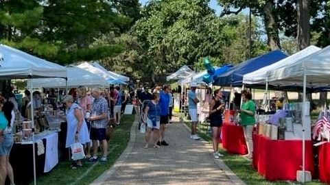 Vendors and Shoppers along Path with Tents and Tables Selling Goods 